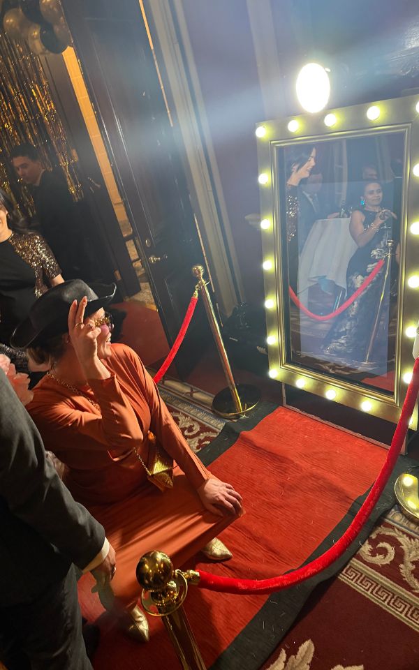 Guests posing at a social event in front of a mirror booth
