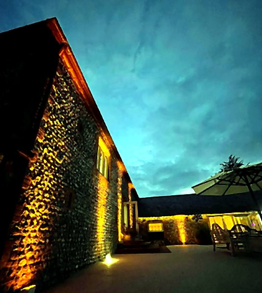 The Ravenswood wedding venue exterior lit with warm uplighting at dusk